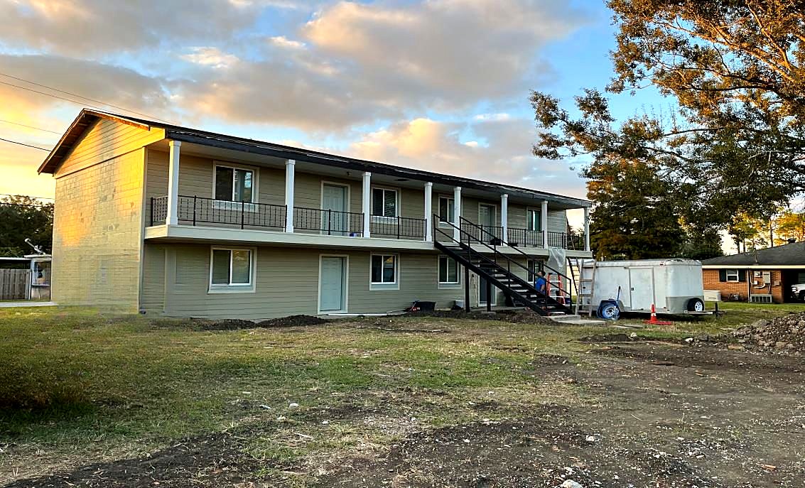 Same apartment complex after renovation with new exterior, railings and stairs